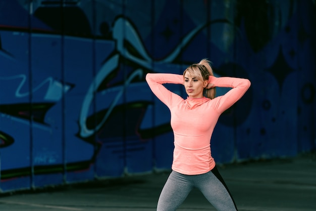 Dedykowanej Blondynki Sportowa Piękna Kobieta Z Poważną Twarzą ćwiczy Outdoors.