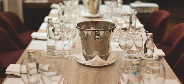 Zdjęcie degustacja wina: stół z listami degustacyjnymi, szklankami, butelkami z wodą i spluwaczką.