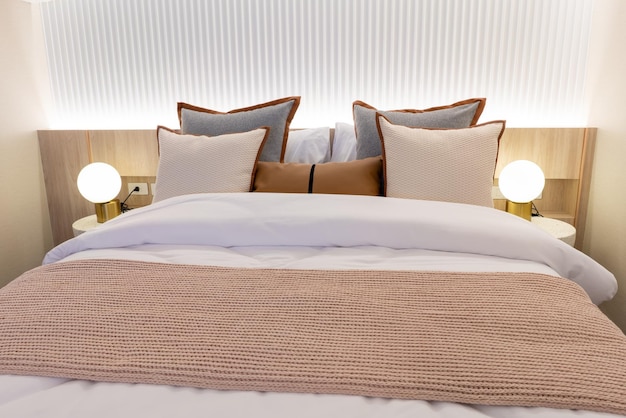 Dekoracja białych poduszek na łóżku we wnętrzu sypialni Wnętrze sypialni z lampami