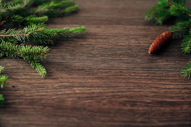 Dekoracja gałęzi choinki na brązowym tle z miejscem na kopię