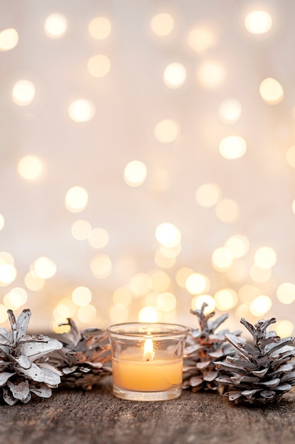 Dekoracja świąteczna szyszki i świeca na drewnianym tle Pionowe zdjęcie
