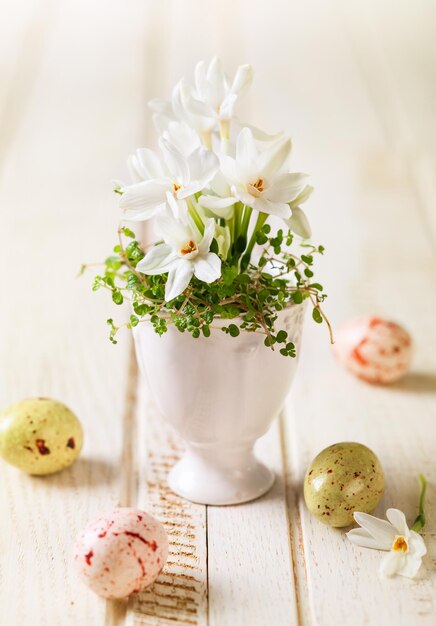 Dekoracja wielkanocna z wiosennymi kwiatami i czekoladowymi jajkami
