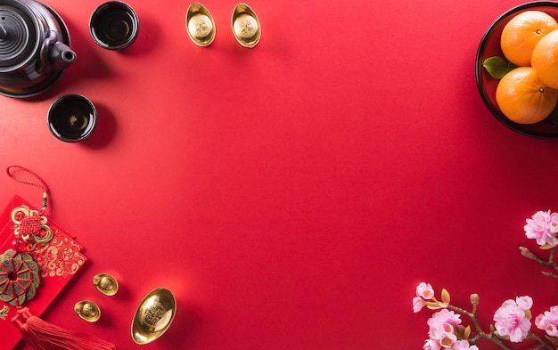 Dekoracje chińskiego nowego roku wykonane z czerwonej paczki pomarańczowych i złotych sztabek lub złotej bryły na czerwonym tle Chińskie znaki FU w artykule odnoszą się do fortuny powodzenia bogactwa przepływu pieniędzy