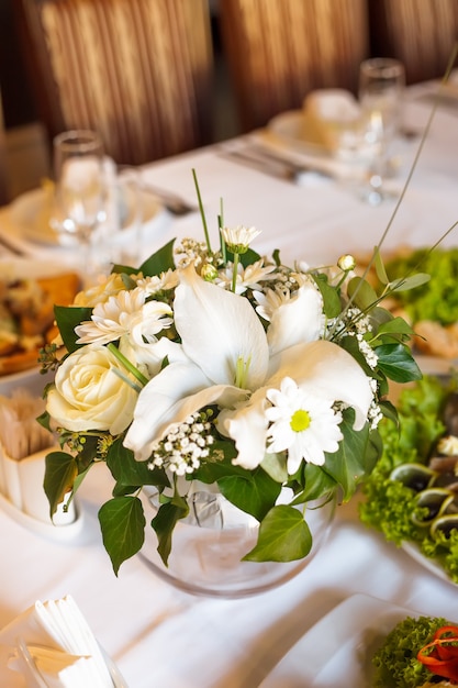 Dekoracje kwiatowe na stole bankietowym, przygotowane na imprezę okolicznościową lub wesele