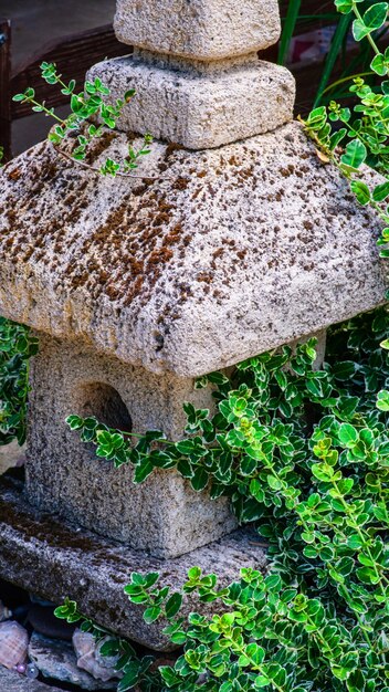 Dekoracje ogrodowe z kamieni i kamienne rzeźby wśród ładnej zieleni