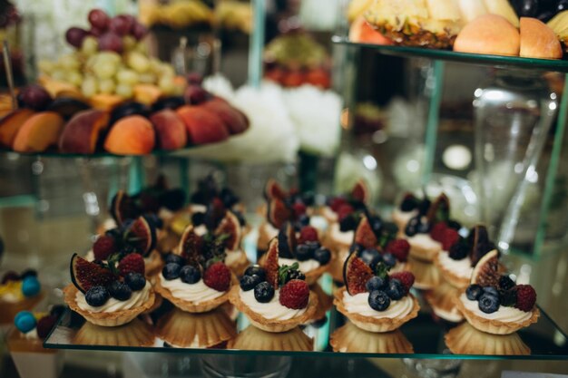 Dekoracje ślubne Recepcja Bufet Owoce i sery na talerzach z pieczywem w pudełkach Bar Food udekorowany kwiatami i lampionami