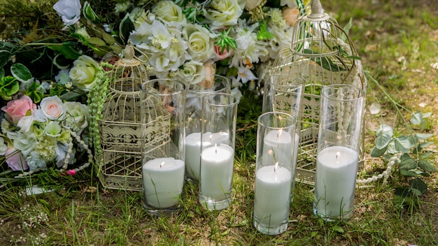 Zdjęcie dekoracje ślubne uroczysta ceremonia. ślub w naturze. świece w ozdobnych słoikach. nowożeńcy. dekoracje ślubne