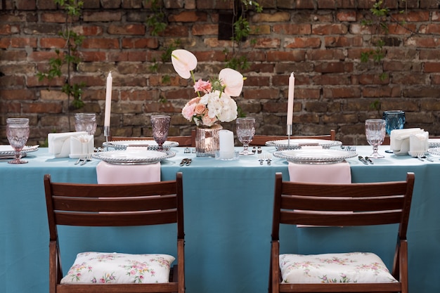 Dekoracje stołu na święta i kolację weselną. Zestaw stołowy na wesele w restauracji na świeżym powietrzu.