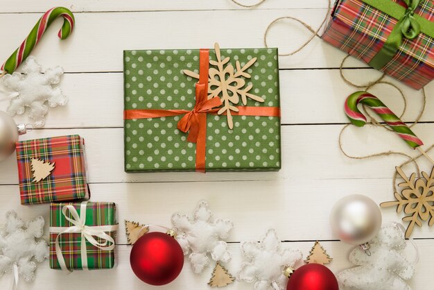 Dekorację świąteczną, pudełka na prezenty, tło koncepcja ramki, widok z góry, na białej powierzchni stołu z drewna. Ozdoby świąteczne i prezenty