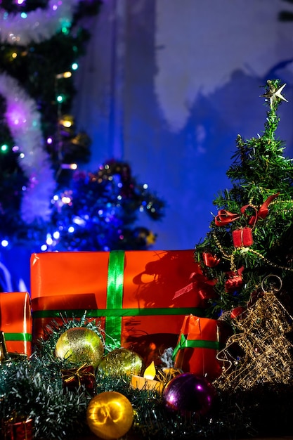 Dekoracje świąteczne z zawiniętymi prezentami na Boże Narodzenie na tle świateł bożonarodzeniowych Sweet Home