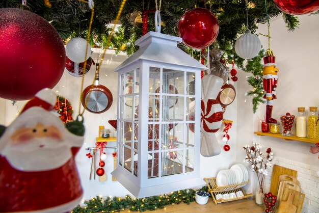 Dekoracyjna biała latarnia przy świecach w przytulnym wystroju wnętrza kuchni na nowy rok i Boże Narodzenie