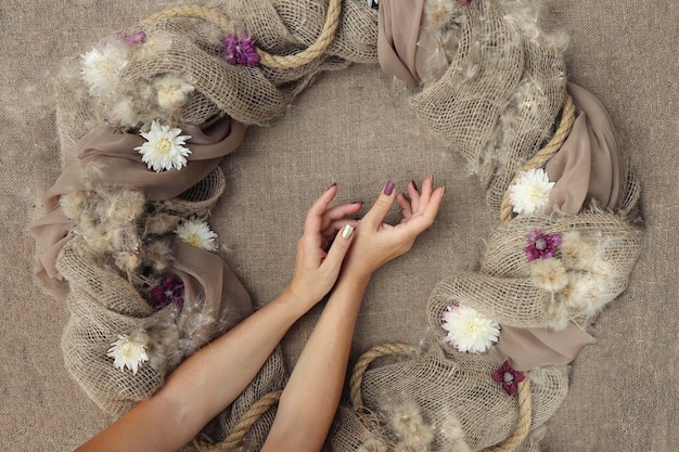 Dekoracyjna dekoracja z kwiatami na płótnie z kobiecymi rękami.