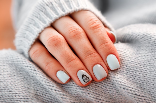 Delikatny manicure pastelowy dla dziewczynki na tle ubrania