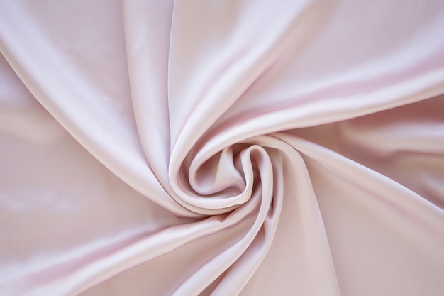 Delikatny pastelowy różowy satynowy składany i płynący projekt dekoracji tła nieostrość luksusowa koncepcja mody i kobiecości różany jedwab tło z krzywymi