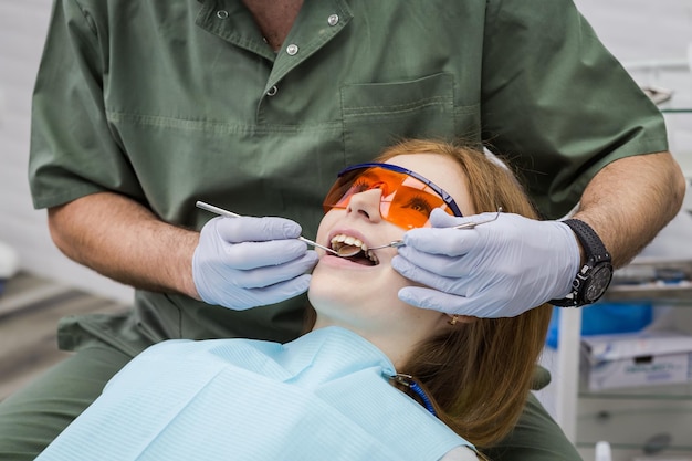 Dentysta badający zęby dziewczynki w klinice Problem stomatologiczny