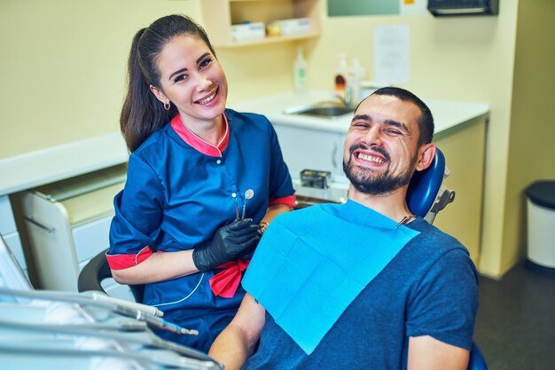 Dentysta badający zęby pacjenta w gabinecie dentystycznym.