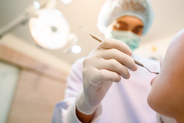 Dentysta badający zęby pacjenta w klinice w celu lepszego zdrowia zębów i jasnego uśmiechu Pacjenci do badania i opieki stomatologicznej w klinice Narzędzia i sprzęt dentystyczny
