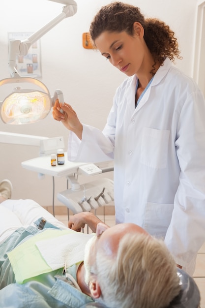 Dentysta badający zęby pacjentów w fotelu dentystycznym