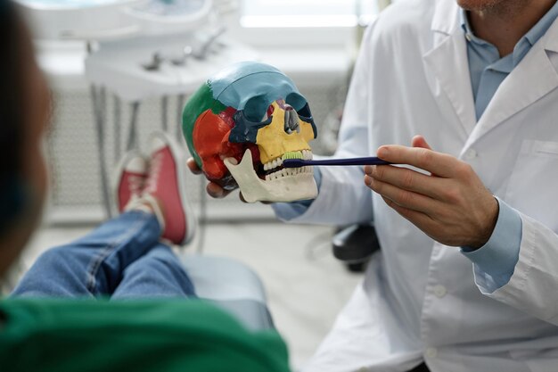 Zdjęcie dentysta demonstrujący technikę szczotkowania zębów w klinice dentystycznej