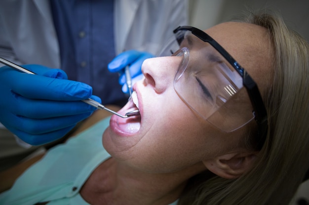 Dentysta egzamininuje kobiety z narzędziami