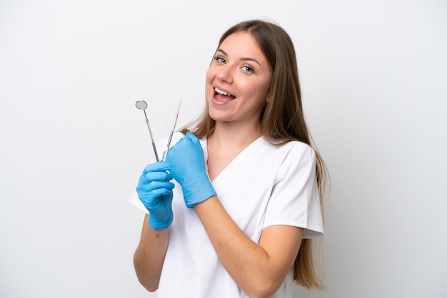 Dentysta kobieta trzymająca narzędzia na białym tle świętująca zwycięstwo