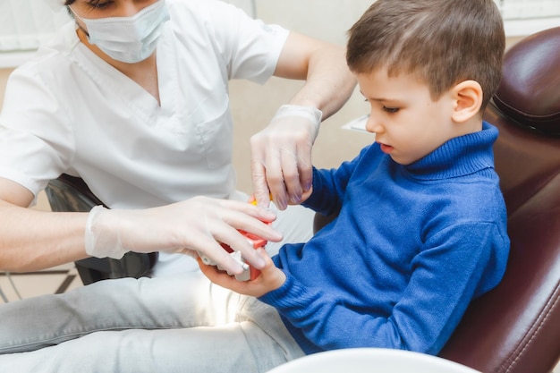 Dentysta Mężczyzna Pokazuje Chłopcu Na Protezie, Jak Prawidłowo Myć Zęby Koncepcja Badania Lekarskiego Dziecka