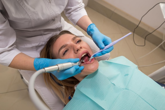 Dentysta przeprowadza zabieg czyszczenia zębów dziewczynce w gabinecie stomatologicznym Usunięcie kamienia nazębnego Koncepcja leczenia stomatologicznego