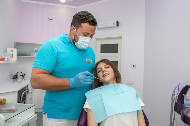 Dentysta sprawdza zęby pacjenta, który przyszedł na badanie uszkodzonych zębów