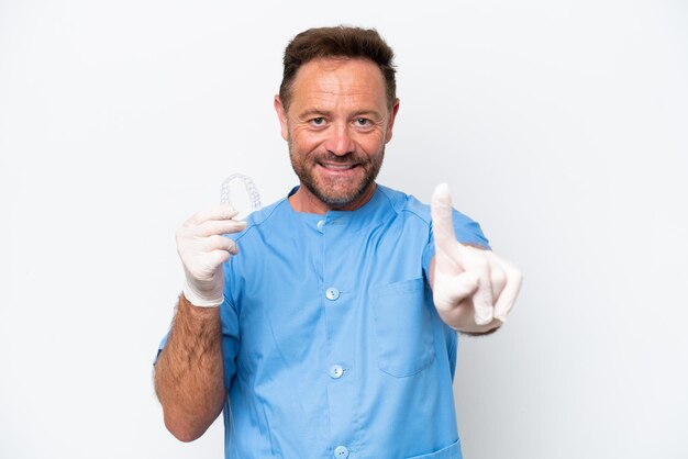Dentysta w średnim wieku, trzymający, przewidujący, odizolowany na białym tle, pokazujący i podnoszący palec