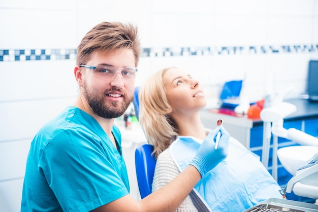 Dentysta ze sprzętem badający młodą dziewczynę