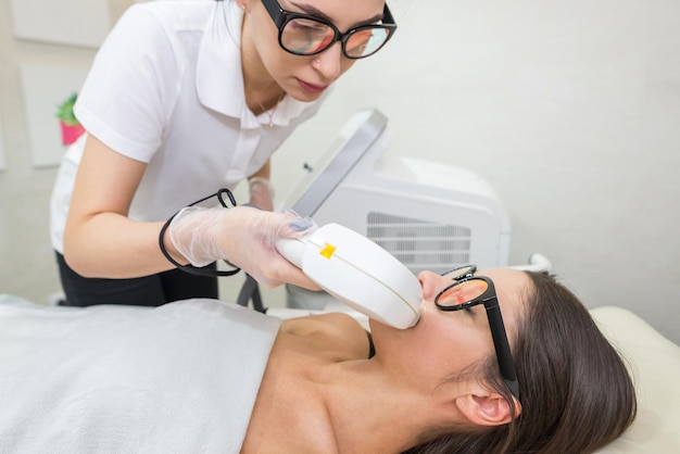 Zdjęcie depilacja laserowa włosy niechciane na twarzy młoda kobieta koncepcja zdrowia i urody młoda kobieta podczas zabiegu depilacji laserowej na twarzy w salonie