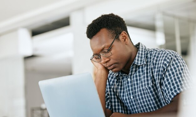 Depresja wypalenia zawodowego i czarny mężczyzna w pracy laptop z e-mailem z terminem i raportem w miejscu pracy inżyniera Zmęczenie zmęczony i myślący pracownik inżynierii niezadowolony z pracy w biurze z problemem