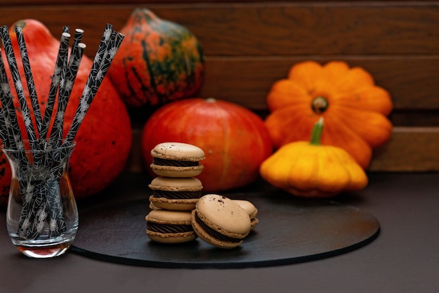 Deser Na Halloween. Menu Na święto Dziękczynienia. Francuskie Makaroniki. Makaroniki Z Czekoladą Na Kamiennej Tablicy Cukierniczej Na Czarnym Tle Z Dyni. Miękka Selektywna Ostrość.