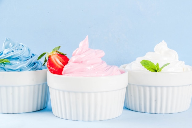 Deser zdrowej diety, mrożony jogurt waniliowy i jagodowy lub lody miękkie w białych miseczkach