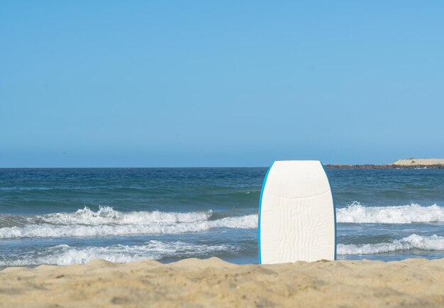 Zdjęcie deska surfingowa jest na plaży nad oceanem.