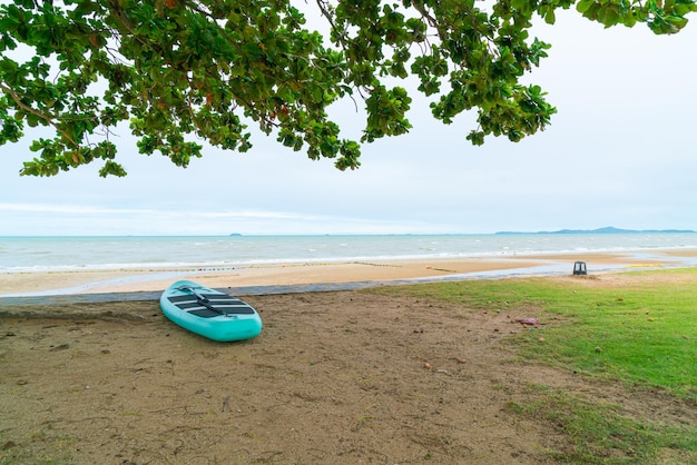 Deska wiosłowa na plaży z tłem morza