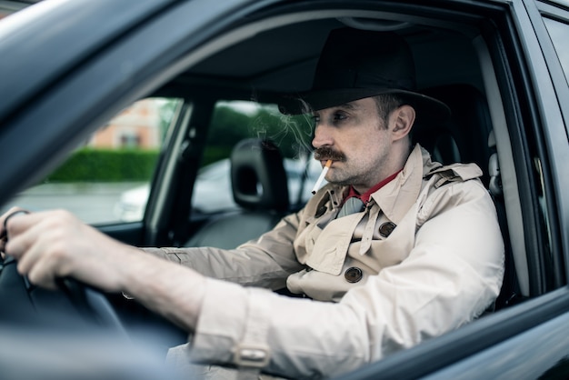 Detektyw lub gangster czekający na kogoś w swoim samochodzie