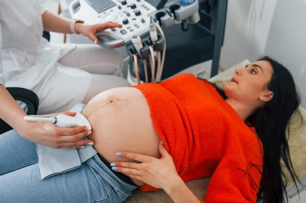 Diagnostyka USG Kobieta w ciąży przebywa w gabinecie w gabinecie i przechodzi badanie stanu zdrowia