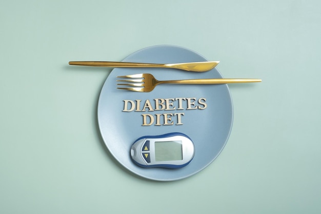 Dieta cukrzycowa tekst Glukometr i widelec w talerzu na kolorowym tle płaski widok z góry Dieta dla diabetyków Minimalna koncepcja