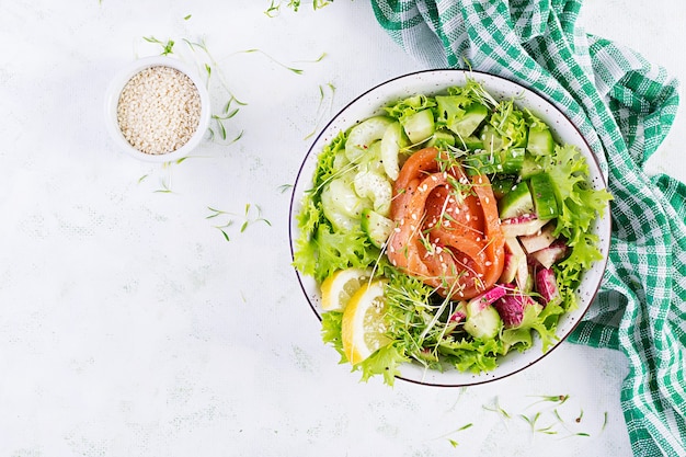 Dieta ketogeniczna śniadanie. Sałatka z łososiem solonym z zieleniną, ogórkami, selerem i rzodkiewką arbuzową. Keto, lunch paleo. Widok z góry, powyżej