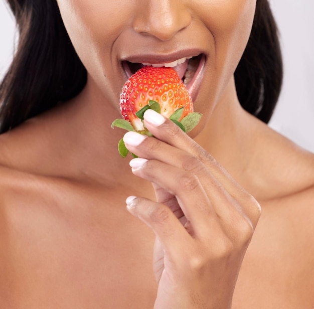 Dieta kobiety i studio z truskawkowymi ustami i jedzenie dla dobrego samopoczucia z piękną wegańską przekąską i zdrowiem Modelowe jedzenie i odżywianie z gryzącymi owocowymi kosmetykami i uwodzicielskim zbliżeniem na tle