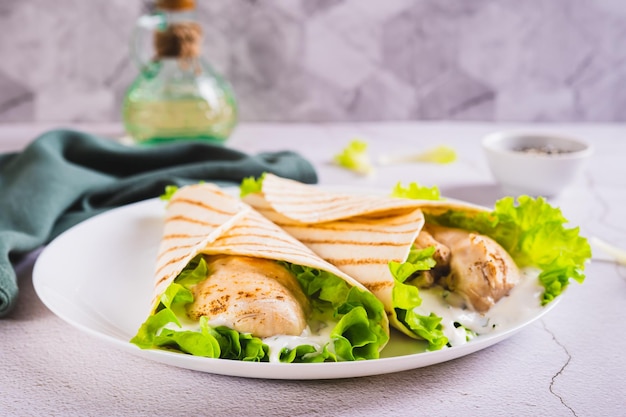 Zdjęcie dietetyczne grillowane tacos z filetem z kurczaka na talerzu na stole