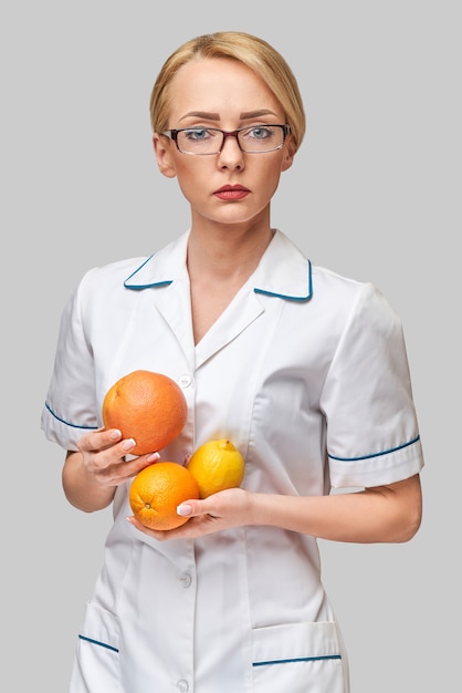 dietetyk lekarz zdrowy styl życia koncepcja - trzymając świeże organiczne owoce cytrusowe - grejpfrut, pomarańcza i cytryna