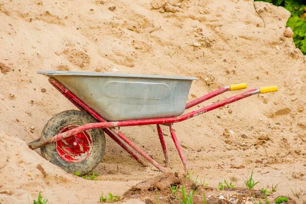 Zdjęcie dirty wheelbarrow near pile of sand