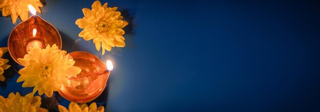 Diwali indyjskie święto Tradycyjne lampy naftowe diya i żółte kwiaty na niebieskim tle Święto światła
