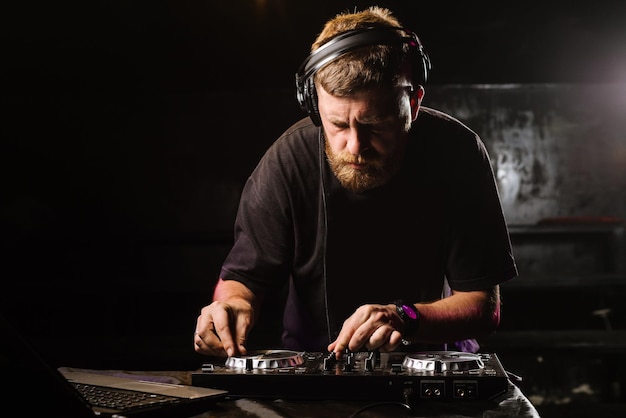DJ gra na mikserze w klubie na czarnym tle