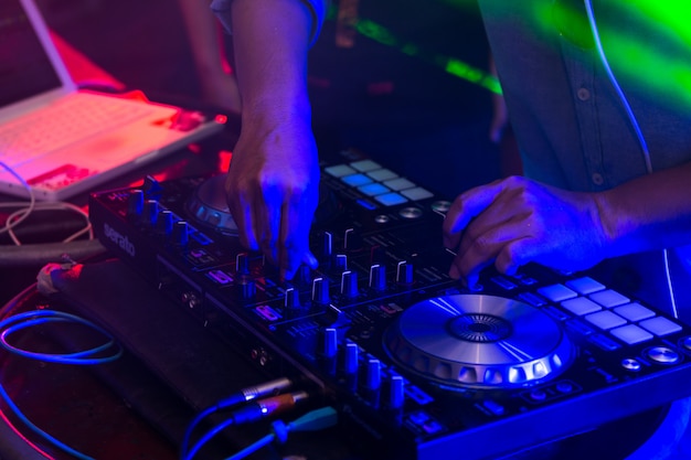 DJ miksujący utwory na mikserze w nocnym klubie.