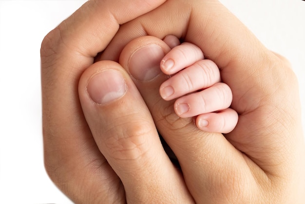 Dłoń śpiącego noworodka w ręku rodziców zbliżenie matki i ojca Drobne paluszki noworodka Rodzina trzyma się za ręce Studio makrofotografii Koncepcje rodziny i miłości