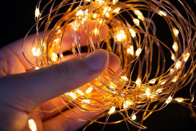 Zdjęcie dłoń trzymająca kolorowe świecące bajki światła wakacyjna świąteczna dekoracja xmas bożonarodzeniowe światła