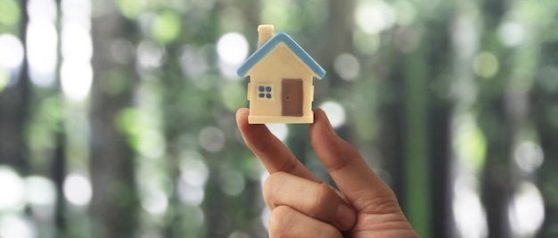 Dłoń trzymająca model domu ubezpieczenie mienia i bezpieczeństwo Kup koncepcję wynajmu domu